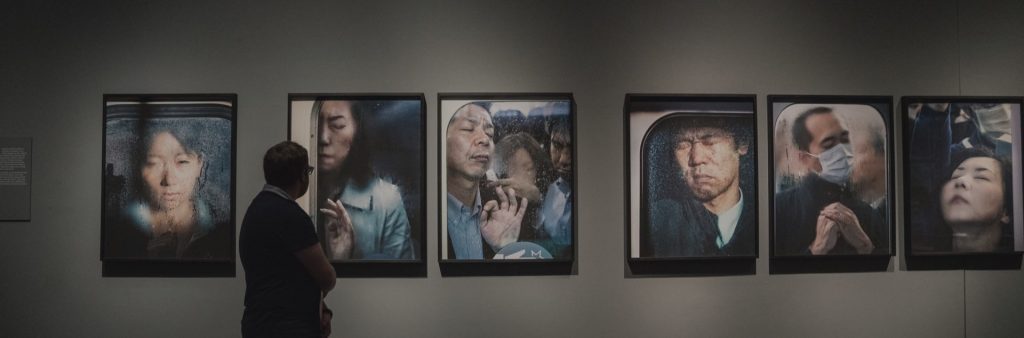 man looking at artworks